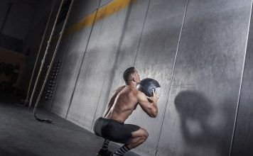 hombre realizando sentadilla de wall ball shot en crossfit